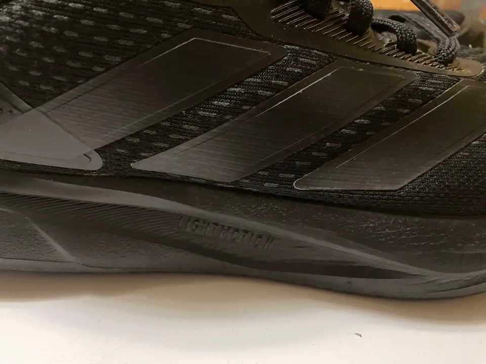 adidas — чёрные беговые, подошва Lightmotion — сбоку